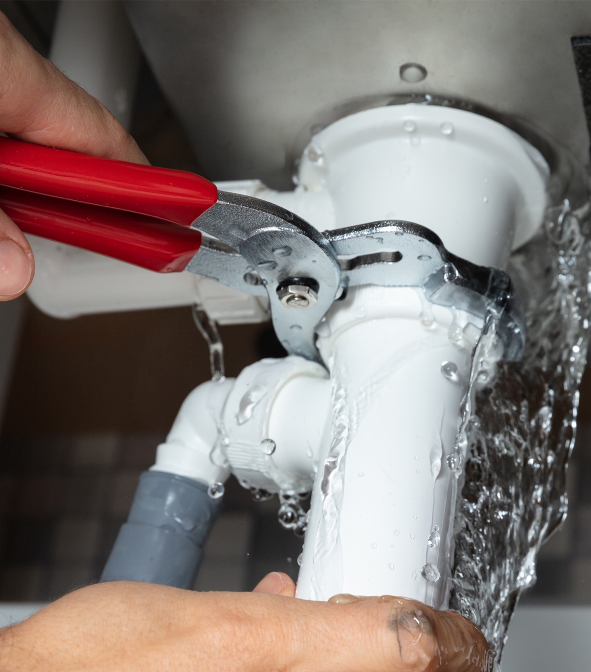 Plumbing fixing a leaky pipe