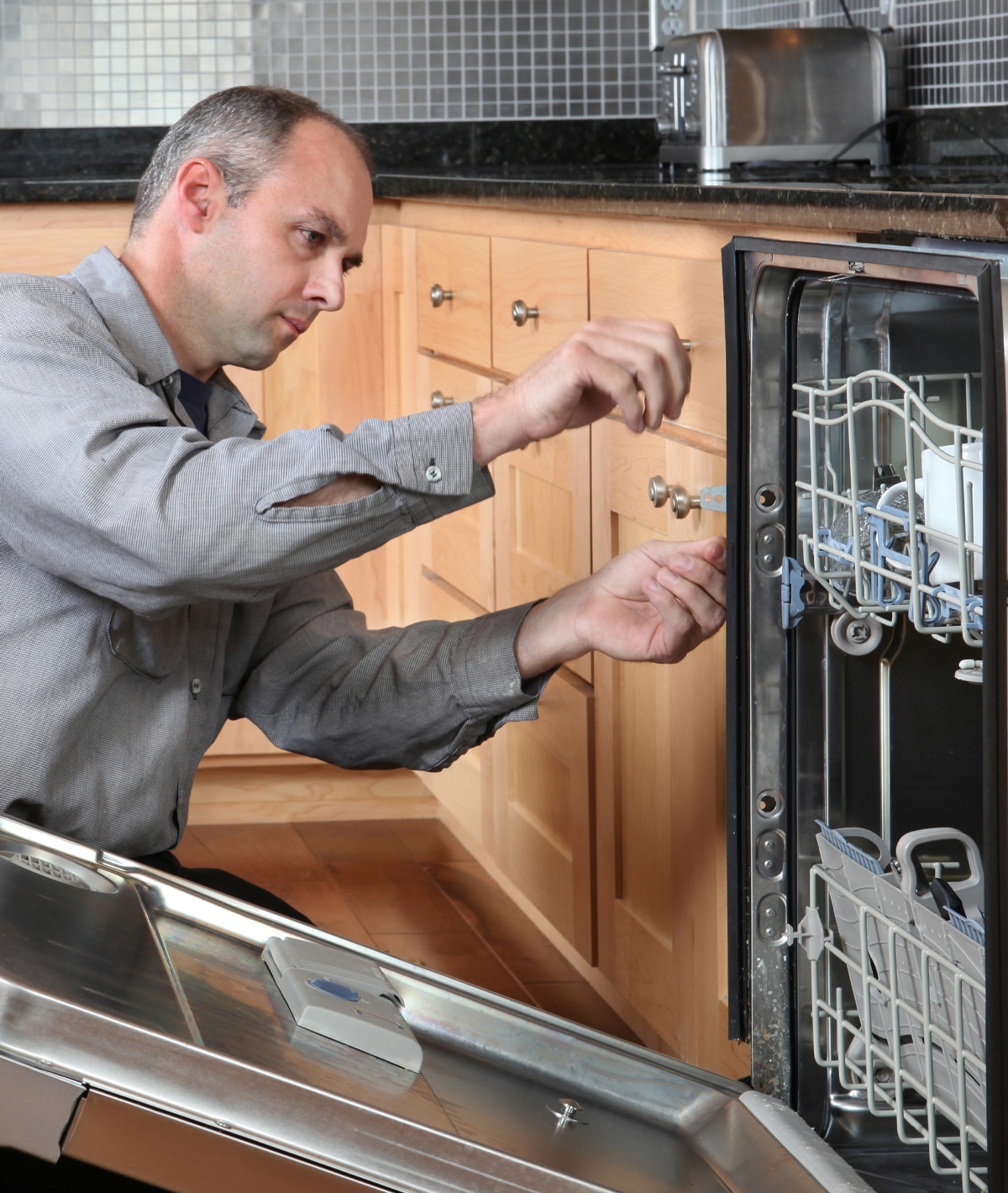 Plumber working on a dishwasher